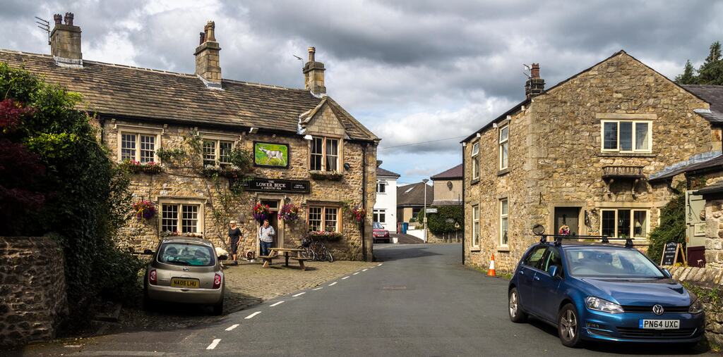 The brook and stone cottages of Waddington village on a bright day